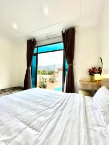 una camera con un letto bianco e una finestra di Milky Villa Moc Chau a Mộc Châu