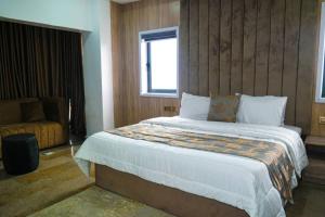 a bedroom with a bed and a chair and a window at NEW VIEW BEACH HOTEL AND RESORT in Lagos