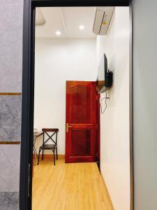 Zimmer mit einer roten Tür und einem Tisch in der Unterkunft Nhà Nghỉ Thảo Tiên in Xóm Tràm Cửa