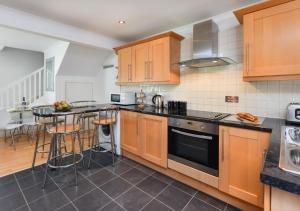 a kitchen with wooden cabinets and a counter top at 243 Cae Du in Abersoch