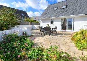 a patio with a table and chairs in a house at 243 Cae Du in Abersoch