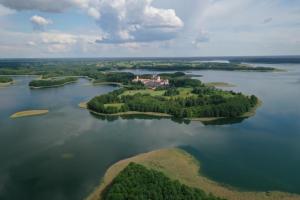 an island in the water with a house on it at Leśniczówka Wigierskiego Parku Narodowego w Maćkowej Rudzie in Krasnopol