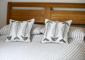 two baseball pillows sitting on top of a bed at Tonnau in Abersoch