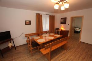 a dining room with a table and a television at Leśniczówka Wigierskiego Parku Narodowego w Maćkowej Rudzie in Krasnopol