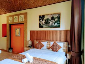 a bedroom with two beds and a painting on the wall at Dukuh Village Villas & Art in Tegalalang