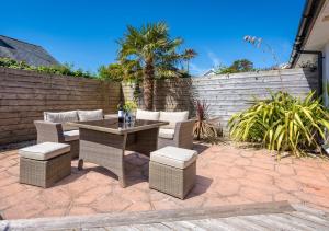 a patio with a table and chairs and a fence at Tonnau in Abersoch