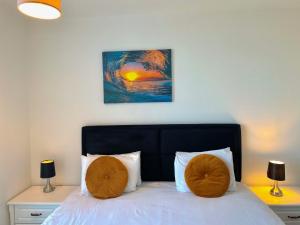 een slaapkamer met een bed met 2 kussens erop bij Berks Luxury Serviced Apartments RWH 76 1 Bedroom, 1 super king bed, free parking, gym & wifi in Bracknell