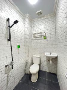 bagno bianco con servizi igienici e lavandino di Ayuri Hotel Malioboro a Sentool