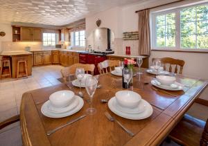 a kitchen with a wooden table with plates and wine glasses at Llecyn in Pwllheli