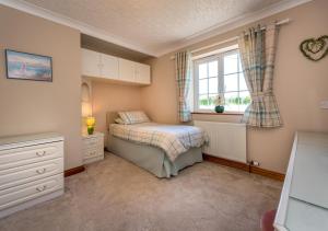 a small bedroom with a bed and a window at Llecyn in Pwllheli