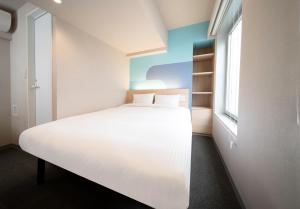 a bedroom with a white bed and a window at Hop Inn Tokyo Ueno in Tokyo