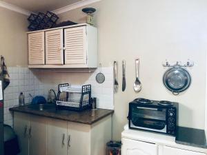 a small kitchen with a sink and a microwave at The Villa in Parys