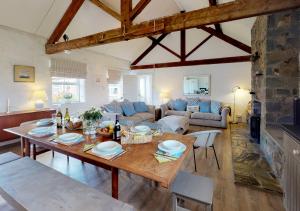 a living room with a wooden table and a living room at Y Stabl in Abersoch
