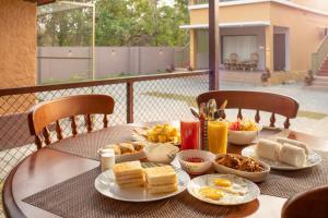 a table with plates of breakfast food on it at Paradise Marari Wellness Resort & Ayurvedic Spa in Alleppey