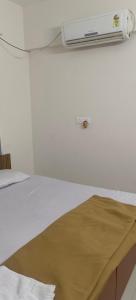 Akshra residency 1 bhk في هنجاودي: غرفة بسرير وسخان على الحائط
