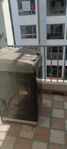 un cubo de basura sentado en el balcón de un edificio en Akshra residency 1 bhk en Hinjewadi