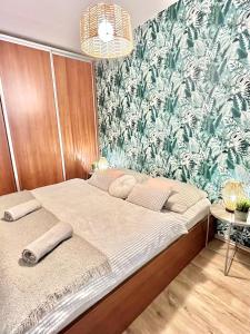 a bedroom with a bed with a green and white wallpaper at URBAN JUNGLE Apartment old town Air Conditioned in Bratislava