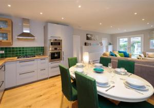 a kitchen and living room with a table and chairs at Lluesta Cottage in Abersoch