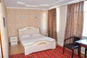 a bedroom with a bed and a desk and a chair at Шинам Мехмонхонаси in Eshonguzar