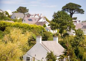a house on a hill with trees and houses at 8 Tai Dyffryn in Abersoch