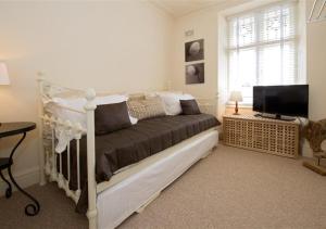 a bedroom with a bed and a television in it at Bronwydd in Abersoch