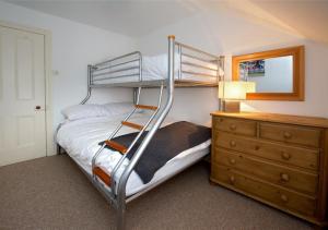 a bedroom with a bunk bed next to a dresser at Bronwydd in Abersoch