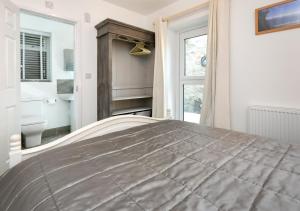 a bedroom with a large bed and a window at Y Cwtch in Llanbedrog