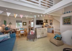 a living room with a blue couch and a kitchen at St Tudwals View in Abersoch