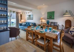 a kitchen and living room with a table and chairs at St Tudwals View in Abersoch