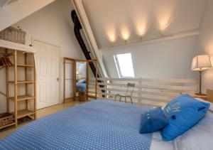 a bedroom with a bed with blue pillows on it at St Tudwals View in Abersoch