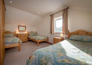 a bedroom with two beds and a window at Bragdy Wern in Llanbedrog