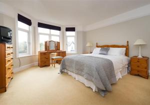 a bedroom with a bed and a tv and windows at Wendon in Abersoch