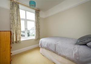 a bedroom with a bed and a window at Wendon in Abersoch