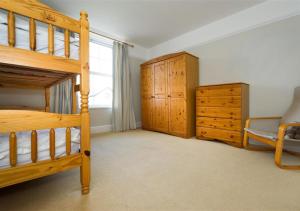 a bedroom with a wooden bunk bed and a dresser at Wendon in Abersoch