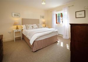 a bedroom with a large bed and a window at Y Betws in Abersoch