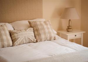 a bed with two pillows and a lamp on a table at Y Betws in Abersoch