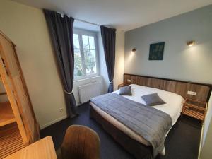 a hotel room with a bed and a window at Logis Hôtel Restaurant L'Odyssée Champêtre in Le Lude