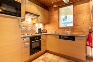 a kitchen with wooden cabinets and a stove top oven at CASA-Chalet Brizolée lake-view chalet in Tignes close to ski area in Tignes