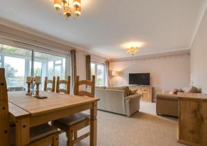 a living room with a table and a couch at Murmur Y Llanw in Port-Eynon