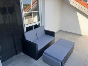 a chair and a stool in front of a window at Kirchdorf Lounge - komplette moderne Ferienwohnung mit Parkplatz nahe A7 in Unteropfingen