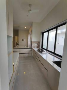 a large kitchen with white counters and a window at Lucky Charm 2BHK Apartment - Muttukadu ECR in Chennai