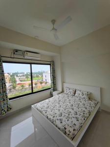 a bedroom with a bed and a large window at Lucky Charm 2BHK Apartment - Muttukadu ECR in Chennai