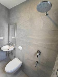 a bathroom with a white toilet and a sink at Lucky Charm 2BHK Apartment - Muttukadu ECR in Chennai