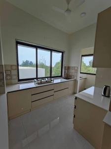 a large kitchen with two sinks and two windows at Lucky Charm 2BHK Apartment - Muttukadu ECR in Chennai