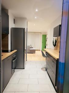 a kitchen with a refrigerator and a living room at Superbe T3 séjour Marseille Clim 2 balcons Timone in Marseille