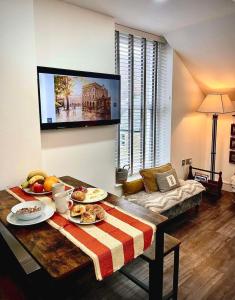 a living room with a table with food on it at Top floor apartment in central Buxton in Buxton