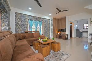 a living room with a brown couch and a table at ll EMPYREAN STAY ll AIRAWAT VILLA ll 2BHK ll AC ll PVT POOL ll LUXURY VILLA ll in Lonavala