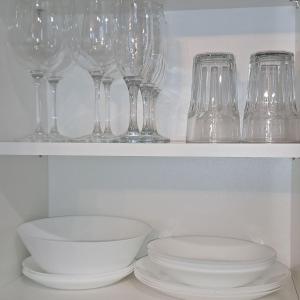 a row of wine glasses and a bowl on a shelf at MHL Apartament Lublin in Lublin