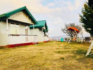 una casa con techo verde junto a un patio en SnowDrop eco resort en Chail