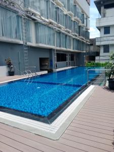 uma grande piscina em frente a um edifício em De'Rain Hotel Bandung em Bandung